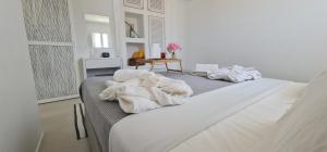 a white room with a bed with towels on it at Lemon Tree Houses in Áno Meriá