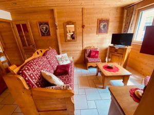 a living room with a couch and a tv in a cabin at Appartement La Clusaz, 3 pièces, 5 personnes - FR-1-459-68 in La Clusaz
