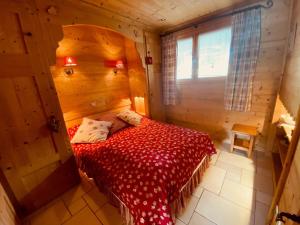 a bedroom with a red bed in a wooden room at Appartement La Clusaz, 3 pièces, 5 personnes - FR-1-459-68 in La Clusaz