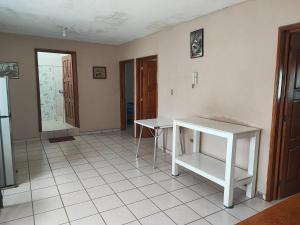 una camera con un tavolo bianco su un pavimento piastrellato di Amplios y cómoda cuartos en fraccionamiento privado 