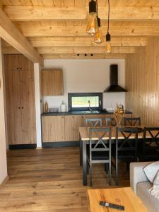 una cucina e una sala da pranzo con soffitto in legno di Kaszubskie Stodoły a Stara Kiszewa