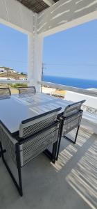 a table and chairs on a patio with a view of the ocean at Lemon Tree Houses in Áno Meriá
