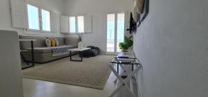 a white living room with a couch and a table at Lemon Tree Houses in Áno Meriá