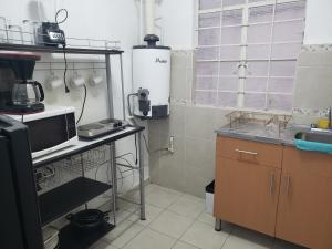 a small kitchen with a sink and a microwave at Singular Centro Histórico in Mexico City +62 photos