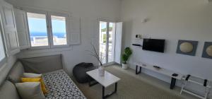 a living room with a couch and a tv at Lemon Tree Houses in Áno Meriá