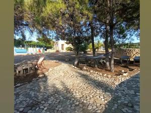 a park with benches and a hammock under a tree at Metochi Gavdos in Gavdos