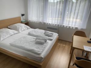 a bedroom with a bed with two towels on it at Sunlight Studio in Balatonföldvár