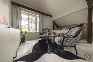 a bedroom with a bed and two chairs and a rug at Villa Chez les Amis - Adults only in Balatonszepezd