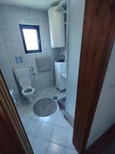 een badkamer met een toilet en een raam bij Apartman Emanuel in Jajce