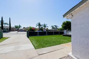 a yard with green grass and a fence at Cozy and Quiet Front House in Fontana