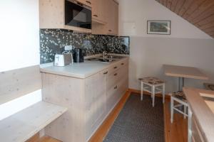 a kitchen with white cabinets and a sink and a table at Guesthause Pr' Jozef in Bled