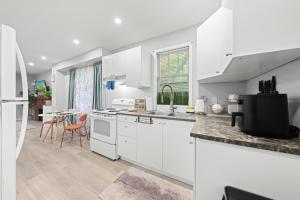 a kitchen with white cabinets and a dining room at Close to mall with private toilet, Free Wi-Fi and Parking in Toronto
