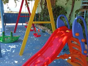 a playground with colorful swings and a slide at Metochi Gavdos in Gavdos