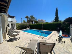 a swimming pool with two chairs and a swing at Villa Tamara with Private Pool in Peyia +41 photos