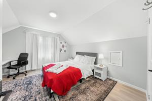 Schlafzimmer mit einem Bett mit einer roten Decke und einem Schreibtisch in der Unterkunft Close to mall with private toilet, Free Wi-Fi and Parking in Toronto