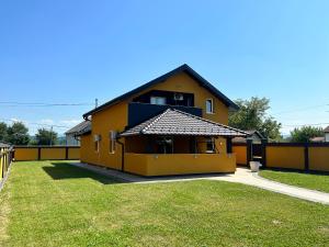 ein gelbes Haus mit einem großen Hof davor in der Unterkunft Vila Veselić in Valjevo