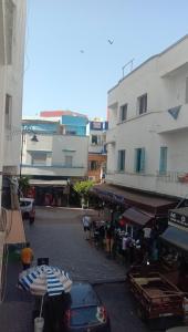 a city street with a group of people and umbrellas at إقامة الصداقة in Larache
