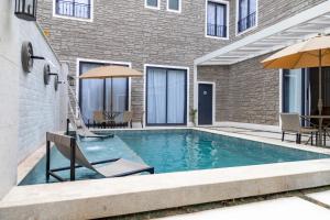 a swimming pool with two chairs and an umbrella at Pousada e Cerimonial Itamaraty in Pedra Azul