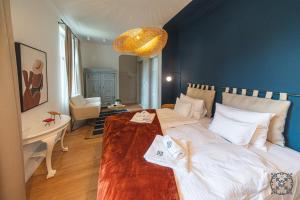 Un dormitorio con una cama grande y una mesa con toallas. en Villa Chez les Amis - Adults only, en Balatonszepezd