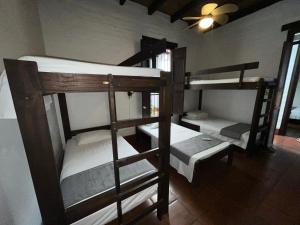 a room with three bunk beds in a house at Hotel Colonial Palmira in Palmira