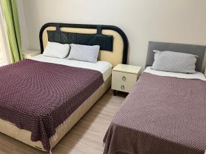 duas camas num quarto com lençóis roxos em Grand Teoshan Otel ve Tatil Evleri em Seferihisar