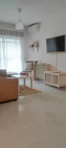 sala de estar con sofá, mesa y TV en Larga 43/1, en La Adrada