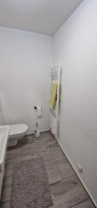 a bathroom with a sink and a toilet and a rug at Break in Kudensee +5 photos