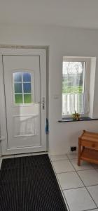 a white door and a window in a room at Break in Kudensee