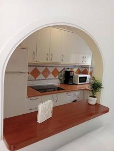 una cucina con arco sopra un ripiano in legno di Apartamento en Fuengirola a Fuengirola