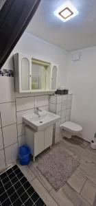 a bathroom with a sink and a toilet at Break in Kudensee