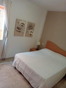 una camera con un letto bianco e una finestra di Apartamento en Fuengirola a Fuengirola