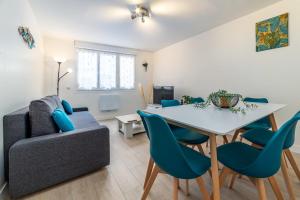 a living room with a couch and a table and chairs at Blue sky cottage near CDG airport in Le Mesnil-Amelot