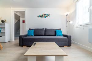 uma sala de estar com um sofá e uma mesa de centro em Blue sky cottage near CDG airport em Le Mesnil-Amelot