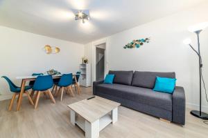 een woonkamer met een bank en een tafel bij Blue sky cottage near CDG airport in Le Mesnil-Amelot