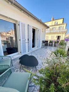 een patio met een bank en een tafel en stoelen bij PARADISE Earth & Sea in Marseille