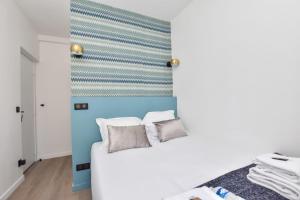a bedroom with a white bed and a blue wall at Résidence Beaugrenelle - Tour Eiffel 1 in Paris
