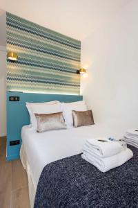 a bedroom with a large white bed with a blue headboard at Résidence Beaugrenelle - Tour Eiffel 1 in Paris