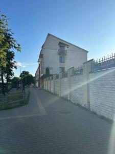 eine Backsteinstraße mit einem Zaun und einem Gebäude in der Unterkunft Paradize in Daugavpils