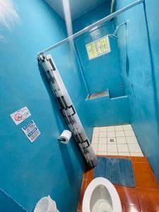 Baño azul con aseo en una cabina en Hostal Mónaco, en San Miguel