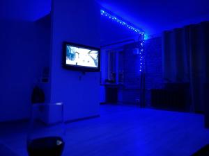 un salon avec une télévision dans une pièce bleue dans l'établissement Loft 2кімнатні Апартаменти Сучасний ремонт WiFi, à Tchernihiv