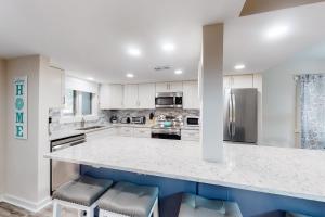een keuken met witte kasten en een aanrecht met krukken bij Stoney Creek Villa 299 in Hilton Head Island