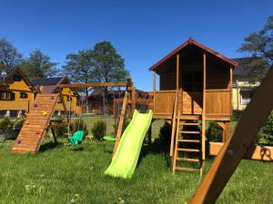 une aire de jeux avec un toboggan et une maison de jeux dans l'établissement Domki nad morzem u Sumy, à Sztutowo