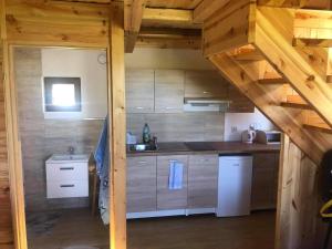 a kitchen with wooden cabinets and a staircase in a cabin at Domki nad morzem u Sumy in Sztutowo