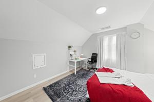 a white bedroom with a red bed and a desk at Close to Centrepoint Mall, Work space, Kitchen with essentials, Free parking in Toronto