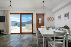 a dining room with a table and chairs and a view at Arte Suites Pefki in Pefki Rhodes