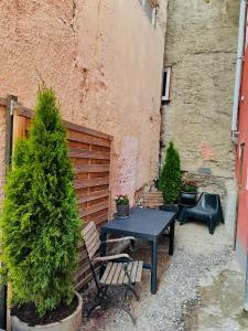 una mesa y sillas en un patio con un pino en Dein Haus am Rhein, en Coblenza