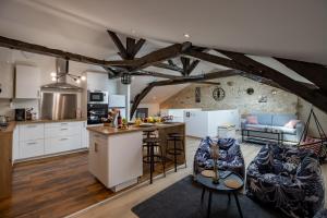 eine offene Küche und ein Wohnzimmer mit Holzbalken in der Unterkunft Le Loft Gîte de Dordogne in Mussidan