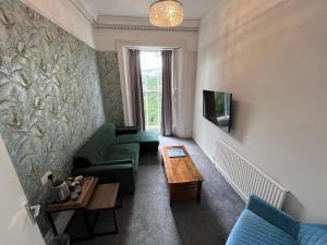 a living room with a couch and a table at Latimer House in Bowness-on-Windermere