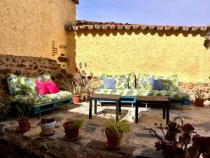 un patio con sofás, una mesa y macetas en La Casa del Marqués, en Logrosán