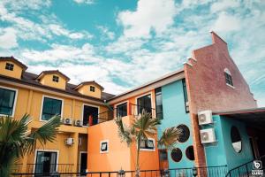 a row of colorful buildings with palm trees in front at Tuscany Hotel Buriram in Buriram